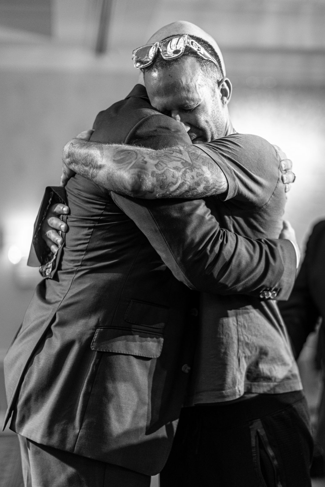 Two men in a tearful embrace at the altar during an altar call