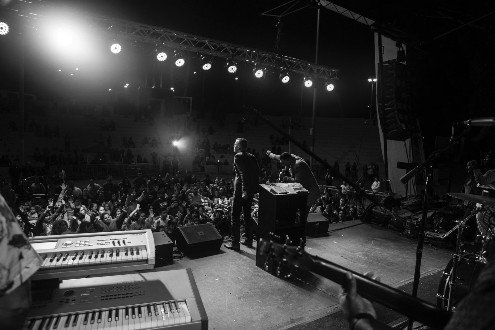Black and white view from the stage of a crusade, with the worship band equipment in front