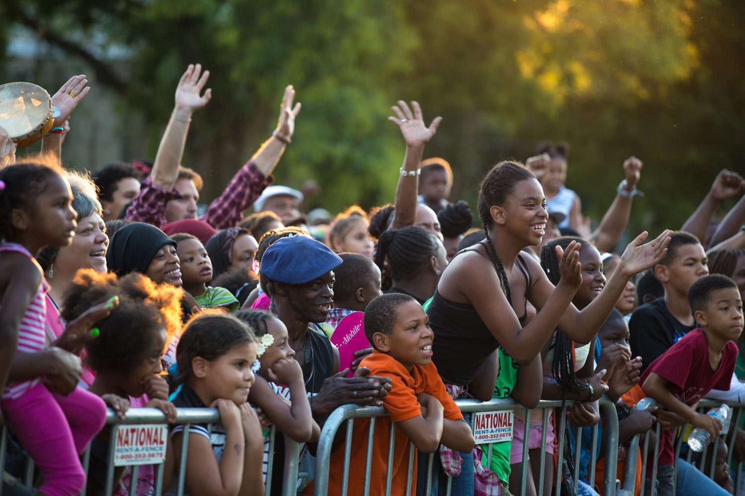 Families with hands raised in worship at an outdoor evangelistic crusade