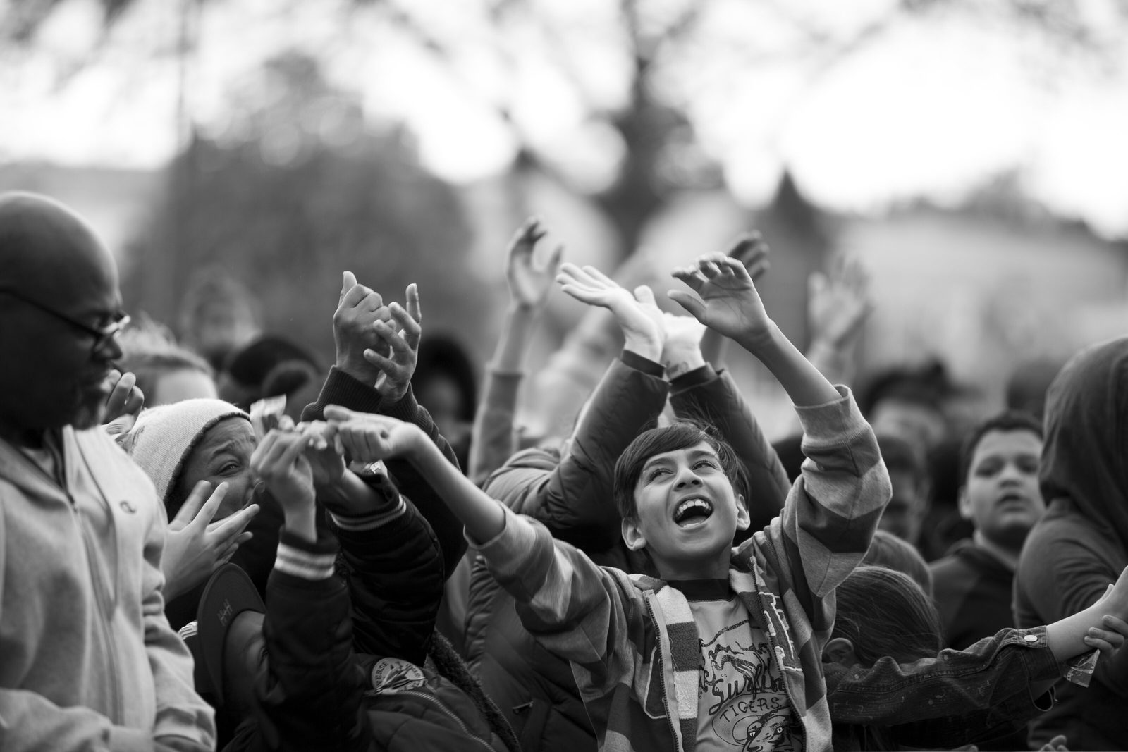 Black and white photo of a crowd worshipping at an outdoor revival meeting